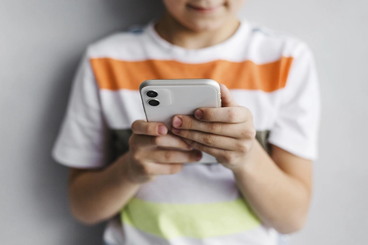 Criança com celular e os problemas do uso excessivo das telas