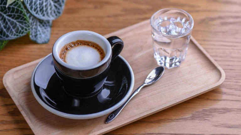 Por que o café vem com um copo de água? A resposta é mais importante do que parece