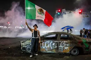 Manifestante em cima de carro com a bandeira do México (Foto: REUTERS)