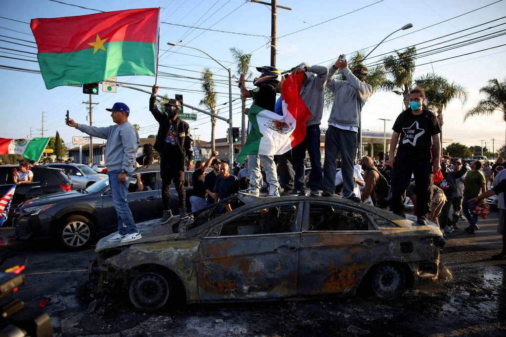 Manifestantes sobem em carro destruído em Compton, na Califórnia