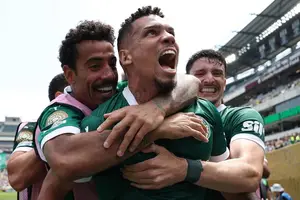 Paulinho é abraçado por companheiros depois de decidir o jogo (Foto: Franck Fife/AFP)