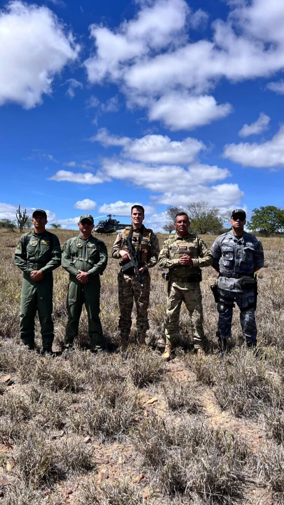 Policiais na mata usam helicóptero