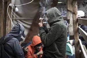 Usuários de drogas se aglomeram em meio a barracos à beira do córrego Antonico, em Paraisópolis, na zona sul de SP (Foto: Danilo Verpa)