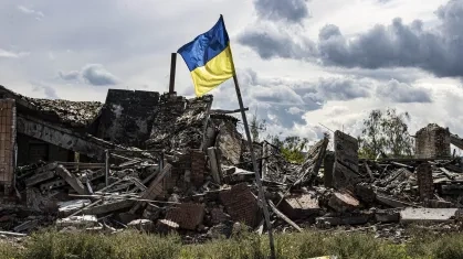 Bandeira ucraniana hasteada em meio à destruição
