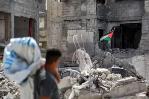 Homem observa bandeira da Palestina hasteada sobre as ruínas em Khan Yunis, no sul da Faixa de Gaza (Foto: Reprodução | Bashar TALEB/AFP)