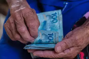 Idoso com o beneficio na mão (Foto: Reprodução)