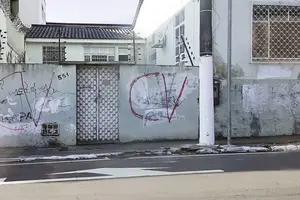 Muros de casa em avenida no centro de Manaus tem pichações em referência ao Comando Vermelho e letras do PCC apagadas com tinta branca (Foto: Reprodução)