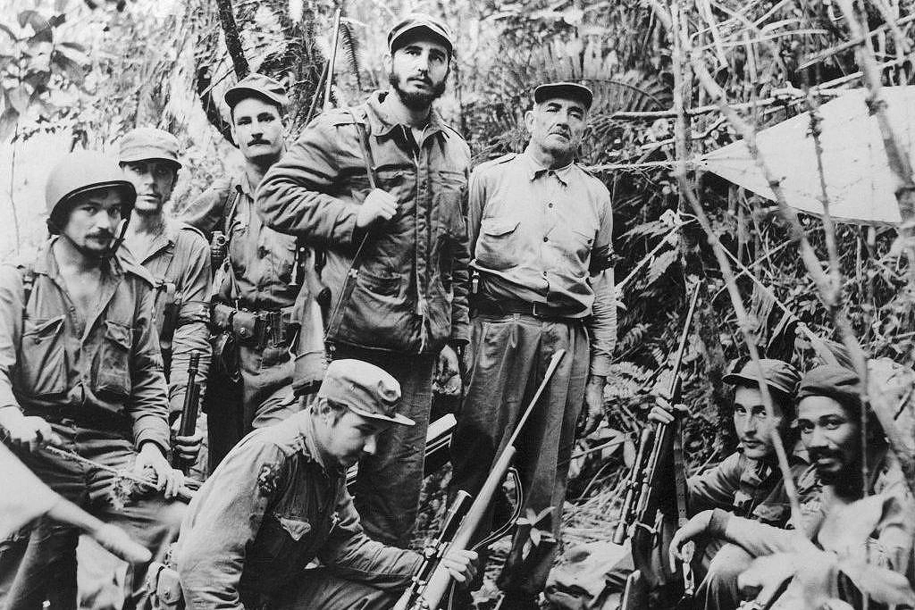 Raúl Castro (ao centro, agachado) junto ao irmão Fidel e outros guerrilheiros que derrubaram o regime de Batista
