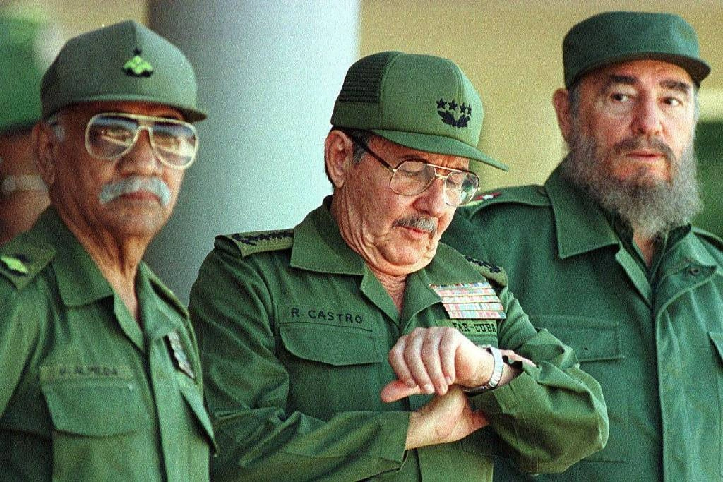 Raúl Castro (no centro) e seu irmão Fidel Castro (à direita)