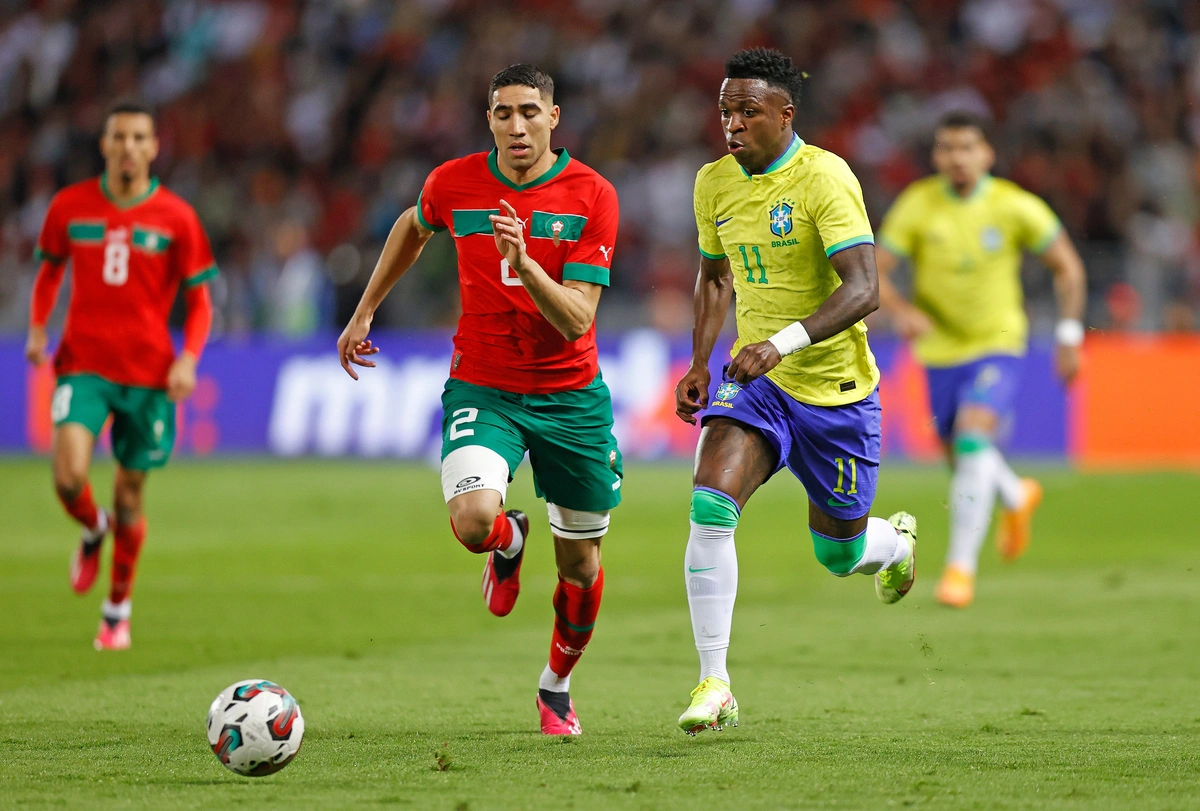 Hakimi e Vinicius Jr. disputam a posse de bola em amistoso entre Brasil e Marrocos, em 2023