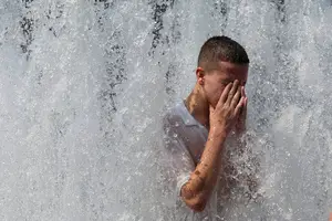 Pedestre se refresca na fonte em frente à Catedral de Berlim, Alemanha, durante a onda de calor (Foto: Reuters)